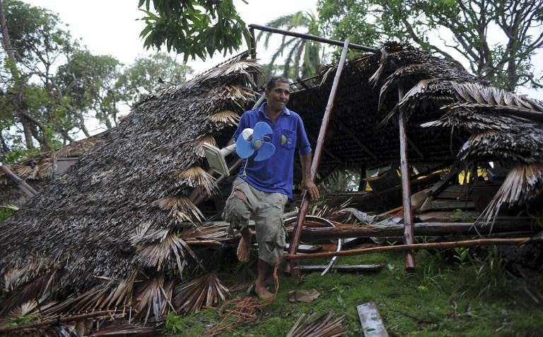 A man salvages a fan amid damaged housing in the Carbonera community of Guantanamo, Cuba following Hurricane Matthew, October 5, 2016. The storm slammed into Haiti and Cuba as a Category Four hurricane on October 4, 2016 but has since been downgraded to three, on a scale of five, by the US National Hurricane Center (NHC).  Its winds were howling at 115 miles per hour (185 kilometers per hour).  / AFP PHOTO / YAMIL LAGE