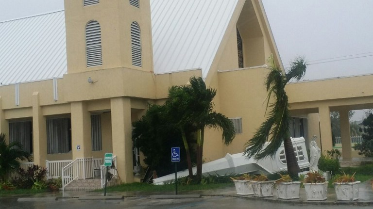 A toppled steeple is seen at St. Gregory's Parish in Nassau, New Providence island in the Bahamas, on October 6, 2016, after the passing of Hurricane Matthew.  Shelters along the eastern coast of Florida were jammed amid a frantic race to protect people and pets from the "potentially catastrophic" effects of Hurricane Matthew as the deadly storm barrels in from the Caribbean. / AFP PHOTO / Royston JONES
