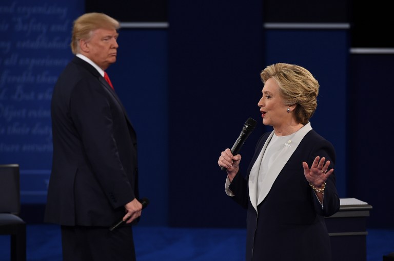 US Democratic presidential candidate Hillary Clinton (R) speaks as US Republican presidential candidate Donald Trump listens during the second presidential debate at Washington University in St. Louis, Missouri, on October 9, 2016. / AFP PHOTO / Robyn Beck