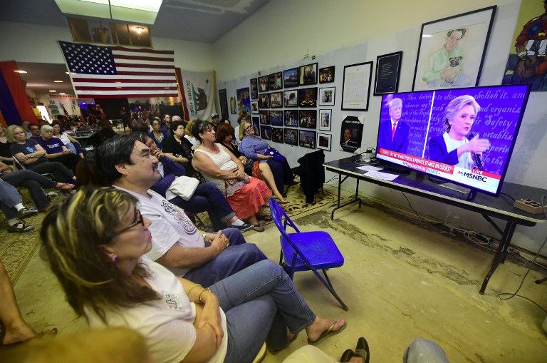 People gather to watch the second presidential debate between US Democratic presidential candidate Hillary Clinton and US Republican presidential candidate Donald Trump at the United Democratic Headquarters in Pasadena, California on October 9, 2016. / AFP PHOTO / FREDERIC J BROWN
