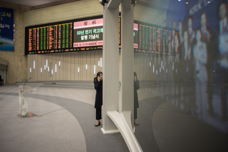 A woman talks on a mobile phone at the Korean Exchange in Seoul on October 12, 2016. Samsung shares plunged on October 10 after the South Korean electronics giant urged global consumers to stop using its Galaxy Note 7 smartphone due to a spate of exploding batteries that raised alarm around the world. / AFP PHOTO / Ed Jones