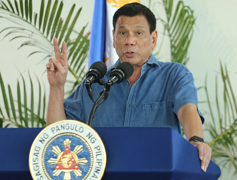 Philippine President Rodrigo Duterte gestures as he delivers his speech prior to departing for a visit to Brunei and China at Davao airport on October 16, 2016.  President Duterte vowed October 16 he will not "barter" away territory and economic rights ahead of a visit to Beijing, where he hopes to mend ties frayed by a row over the South China Sea. / AFP PHOTO / MANMAN DEJETO