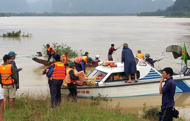 This picture taken on October 16, 2016 shows a police speedboat, loaded with boxes of instant noodles, preparing to leave to distribute the boxes as relief aid to flood-hit people in the central province of Quang Binh. Severe flooding in central Vietnam has killed at least 25 people and destroyed thousands of homes, officials said on October 17, as the country braced for further destruction with a typhoon barrelling closer. / AFP PHOTO / Vietnam News Agency / STR