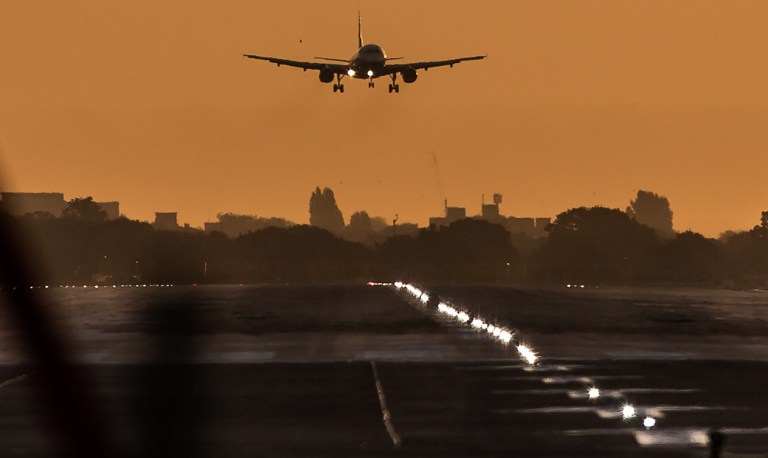 A passenger aircraft prepares to land during sunrise at London Heathrow Airport in west London on October 17, 2016. Britain's government is considering whether to approve a third runway at Heathrow or expand air capacity in southeast England at another airport such as London Gatwick. / AFP PHOTO / Daniel Leal-Olivas