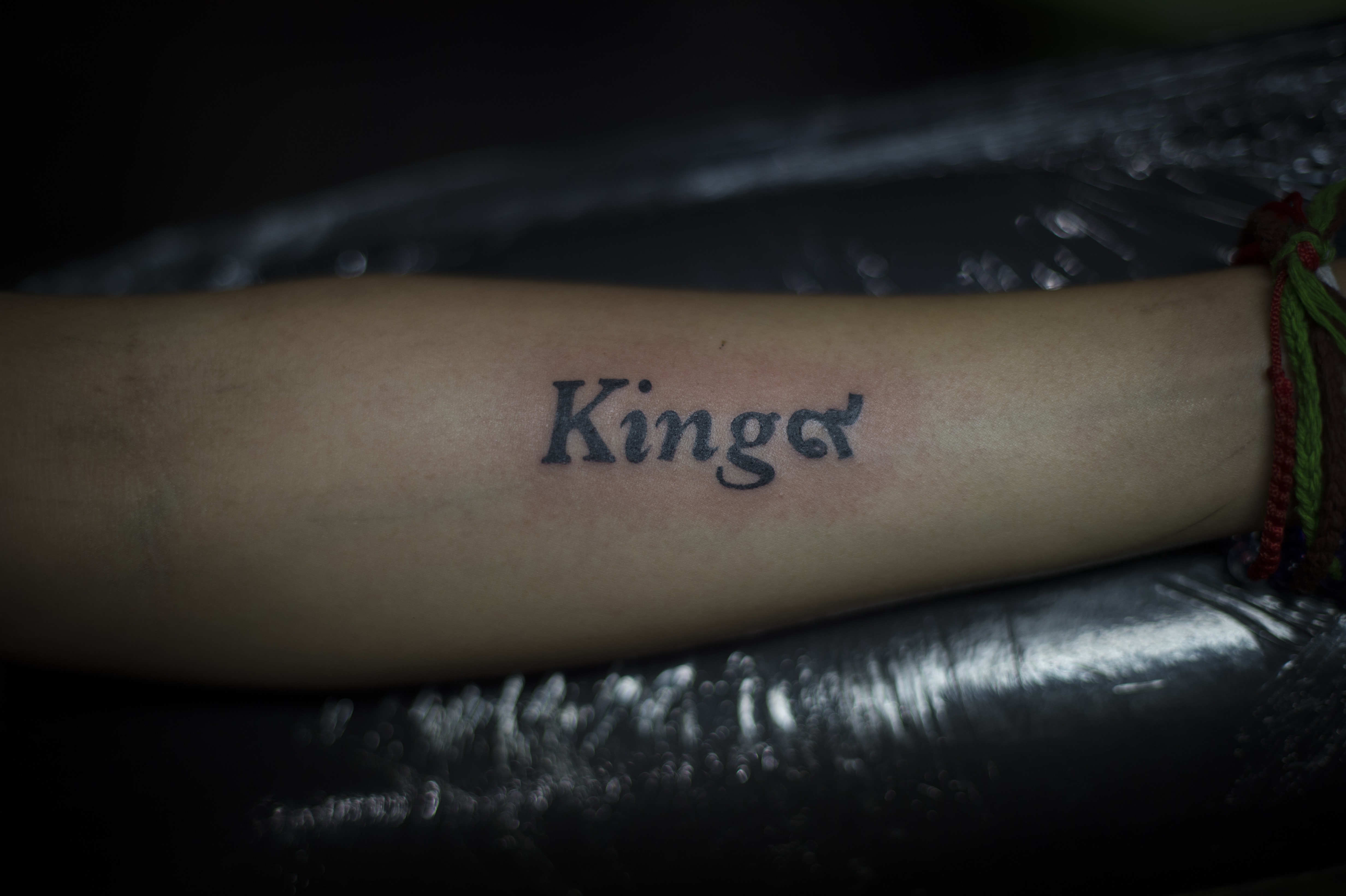 This photo taken on October 18, 2016 shows a finished tattoo "King 9" in honour of the late Thai King Bhumibol Adulyadej at Tattoo OD Studio in Bangkok.  Bhumibol Adulyadej is the ninth king of the current Chakri Dynasty. Thailand's King Bhumibol Adulyadej died at the age of 88 on October 13 after years of ill health, ending a seven-decade reign and leaving the politically divided nation without its key pillar of unity.  / AFP PHOTO / LILLIAN SUWANRUMPHA