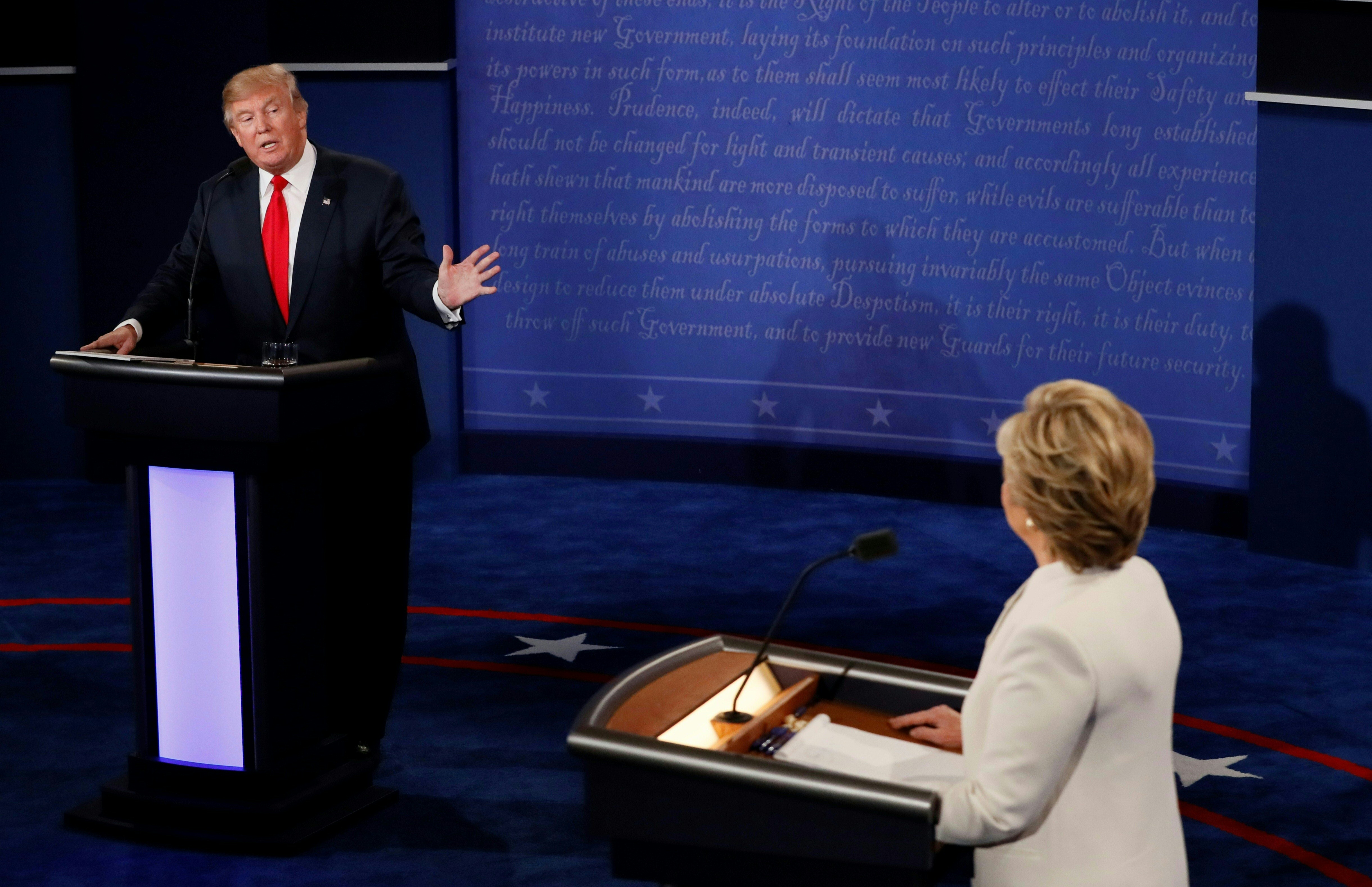 Republican presidential nominee Donald Trump speaks as Democratic presidential nominee Hillary Clinton (R) looks on during the final presidential debate at the Thomas & Mack Center on the campus of the University of Las Vegas in Las Vegas, Nevada on October 19, 2016. / AFP PHOTO / Mark RALSTON