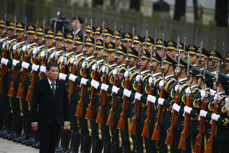 President of the Philippines Rodrigo Duterte and Chinese President Xi Jinping (not pictured) review the guard of honors as they attend a welcoming ceremony at the Great Hall of the People in Beijing, China, October 20, 2016. / AFP PHOTO / POOL / THOMAS PETER