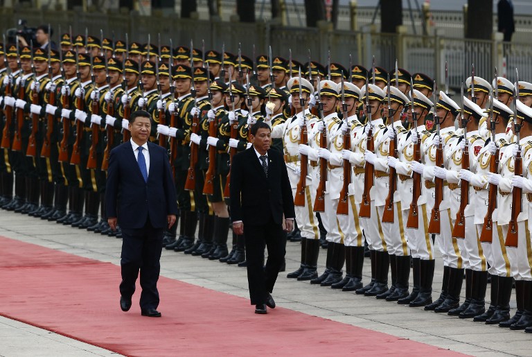 President of the Philippines Rodrigo Duterte (R) and Chinese President Xi Jinping(L) review the guard of honors as they attend a welcoming ceremony at the Great Hall of the People in Beijing, China, October 20, 2016. / AFP PHOTO / POOL / THOMAS PETER