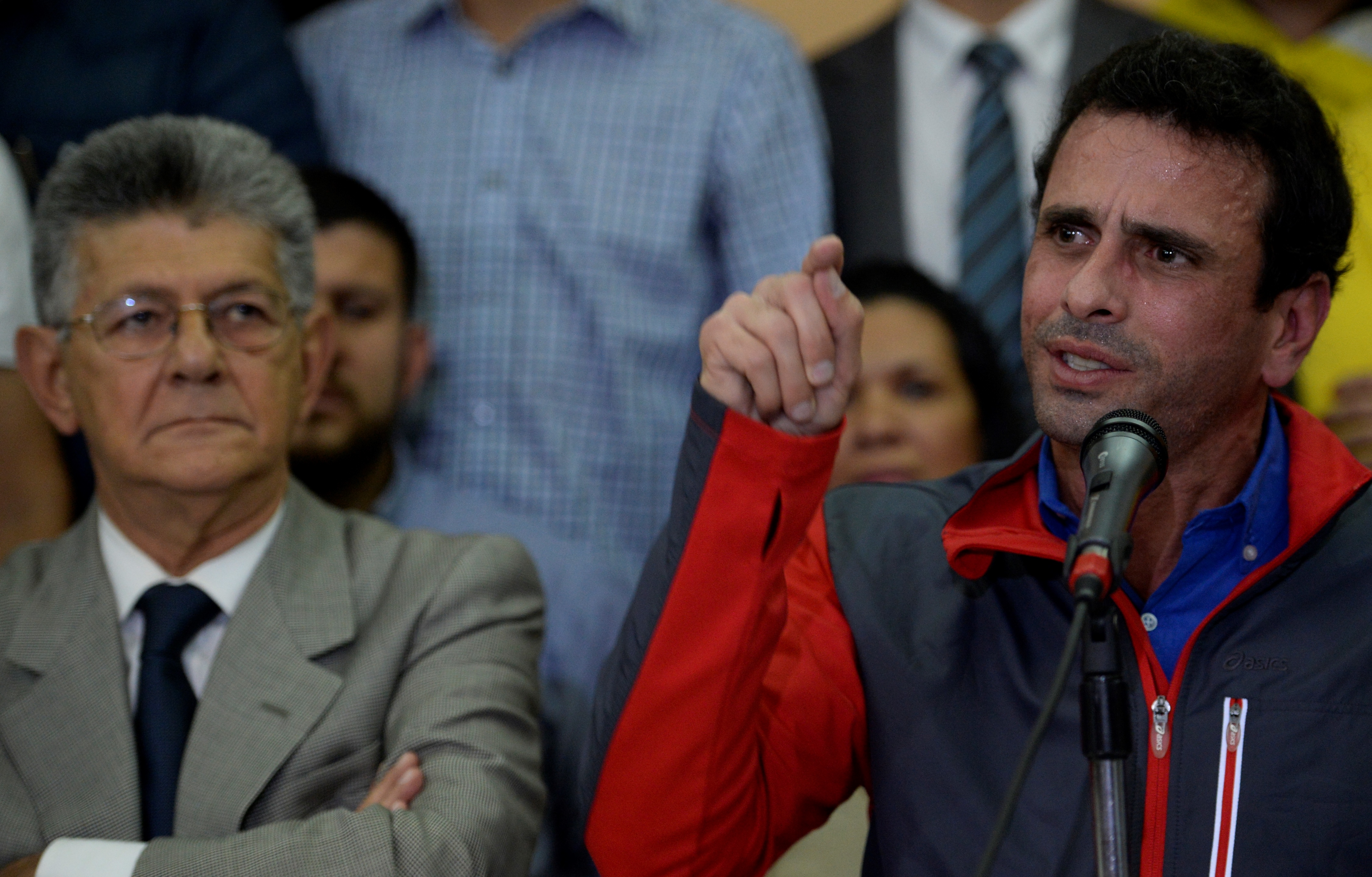 Venezuelan opposition leader Henrique Capriles speaks next to the president of the National Assembly, Henry Ramos Allup, during a press conference in Caracas on October 21, 2016. A furious Venezuelan opposition Friday vowed mass protests, accusing the Socialist government of staging a coup by blocking its drive for a recall referendum against President Nicolas Maduro. / AFP PHOTO / Federico PARRA