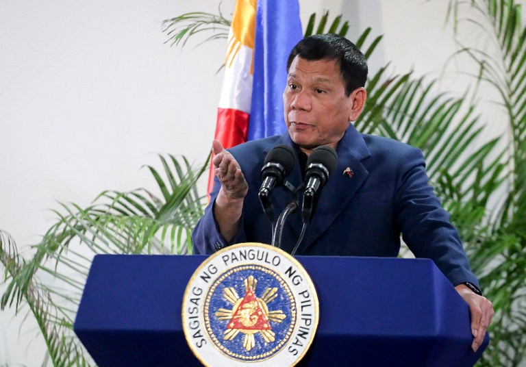 Philippine President Rodrigo Duterte gestures as he speaks at the Davao International Airport after arrving back from a state visit to Brunei and China on October 22, 2016. Philippine President Rodrigo Duterte said on October 22 he would not sever his nation's alliance with the United States, as he clarified his announcement that he planned to "separate". / AFP PHOTO / MANMAN DEJETO
