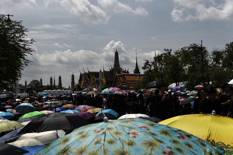 Thousands of mourners clad in black gather in front of the Grand Palace to pay respects to the late Thai King Bhumibol Adulyadej in Bangkok on October 22, 2016. Thailand's King Bhumibol Adulyadej died at the age of 88 on October 13 after years of ill health, ending a seven-decade reign and leaving the politically divided nation without its key pillar of unity. / AFP PHOTO / LILLIAN SUWANRUMPHA