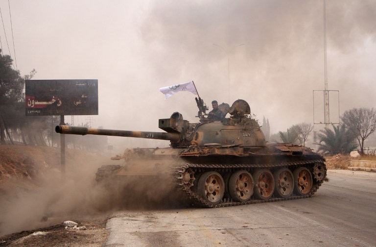 Rebel fighters from the Jaish al-Fatah (or Army of Conquest) brigades manoeuver a T-55 tank as they take part in a major assault on Syrian government forces West of Aleppo city on October 28, 2016. Syrian opposition fighters launched a major assault on government forces to break a months-long siege of rebel-held neighbourhoods of the battered city of Aleppo. Rebel groups including the powerful Ahrar al-Sham faction and former Al-Qaeda affiliate Fateh al-Sham Front fired waves of rockets into government-held western Aleppo, killing at least 15 civilians, a monitor said. The rebels also targeted government positions east of Aleppo city and in the coastal province of Latakia. / AFP PHOTO / Omar haj kadour