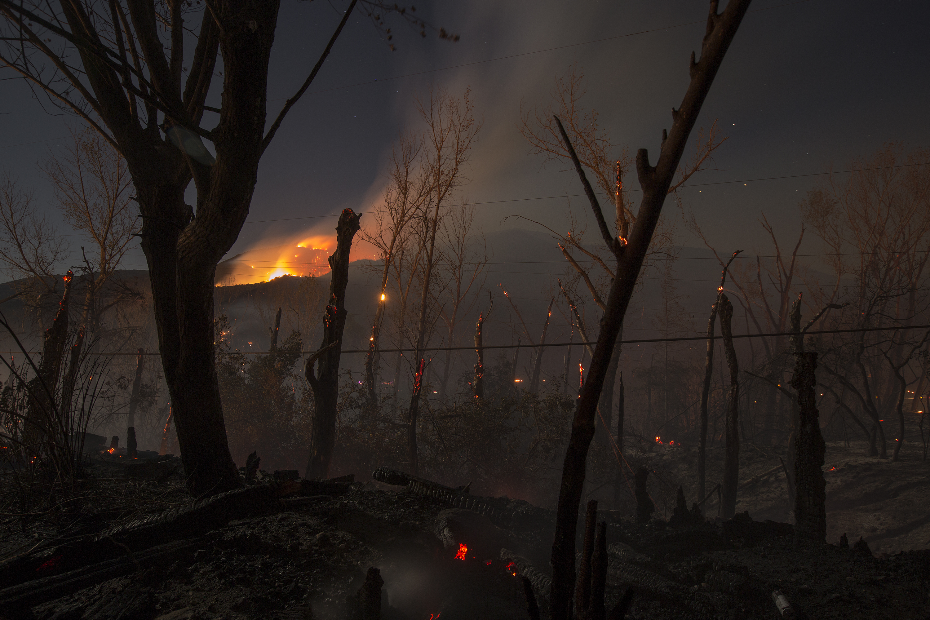 WRIGHTWOOD, CA - AUGUST 17: Fire spreads overnight at the Blue Cut Fire on August 17, 2016 near Wrightwood, California. An unknown number of homes and businesses have burned and more than 80,000 people are under evacuation orders as the out-of-control wildfire spread beyond 30,000 acres and threatens to expand into the ski resort town of Wrightwood. David McNew/Getty Images/AFP