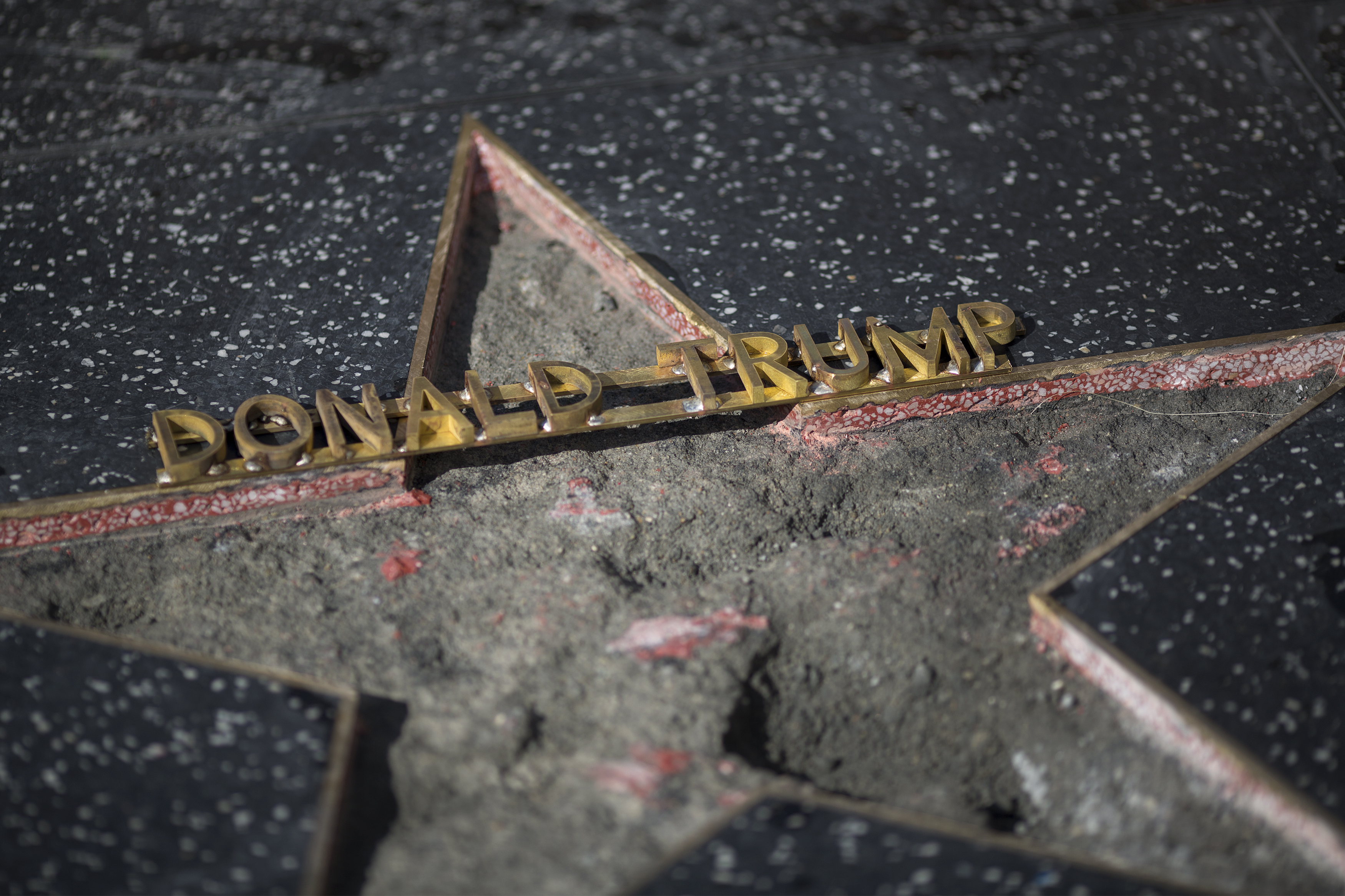 HOLLYWOOD, CA - OCTOBER 26: The Hollywood Walk of Fame star of Republican presidential candidate Donald Trump is repaired after it was vandalized by a protester on October 26, 2016 in Hollywood, California. James Lambert Otis claims to have originally intended to remove the entire star to auction it off and give the money to about a dozen women who allege that Trump groped or sexually mistreated them. Dressed as a construction worker and using a hammer and pick, Otis was only able to break up part of the star. David McNew/Getty Images/AFP