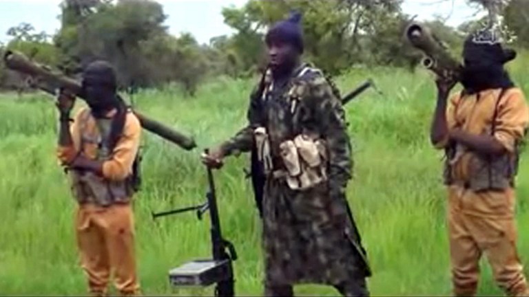This screengrab taken on August 8, 2016 from a Boko Haram video released by the Nigerian Islamist extremist group Boko Haram and obtained by AFP shows Boko Haram's shadowy leader Abubakar Shekau as he appeares in a new video vowing to fight on, shrugging off an apparent split in the hardline jihadist group blamed for thousands of deaths since 2009. "I... Abubakar Ash-Shakawy (Shekau), the leader of Jama'atu Ahlissunnah Lidda'awati Wal Jihad, made it a duty for myself (to fight) Nigeria and the whole world," Shekau said in the video released on August 7, 2016, using the group's name since it declared allegiance to the so-called Islamic State. / AFP PHOTO / BOKO HARAM AND AFP PHOTO / HO