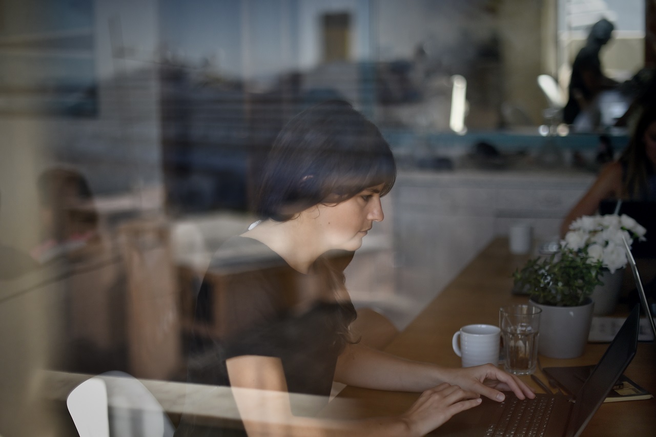 An employee of the French startup company "Moneytis" works on her computer at their office in Lisbon on September 29, 2016. Lisbon hopes hosting the Web Summit, Europe's largest tech event, will spur the development of startups, attract more foreign entrepreneurs and help it compete with the continent's main hubs for innovation. / AFP PHOTO / PATRICIA DE MELO MOREIRA