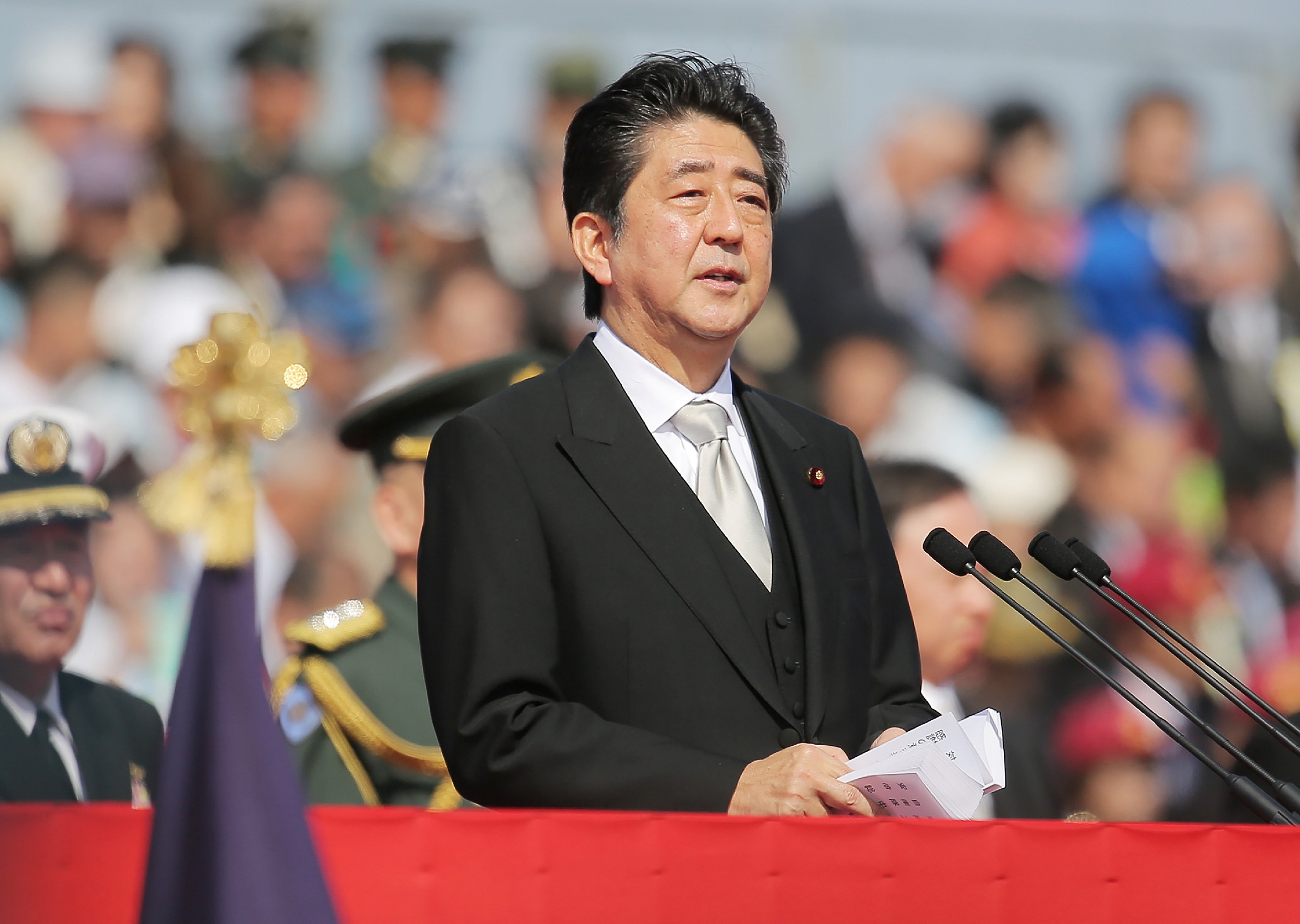 Japanese Prime Minister Shinzo Abe (C) speaks to soldiers of the Ground Self-Defense Force during a military parade at Camp Asaka in Asaka, Saitama prefecture, on October 23, 2016. Some 4,000 personnel, 280 vehicles and 50 aircrafts took part in the military parade. / AFP PHOTO / JIJI PRESS / JIJI PRESS / Japan OUT