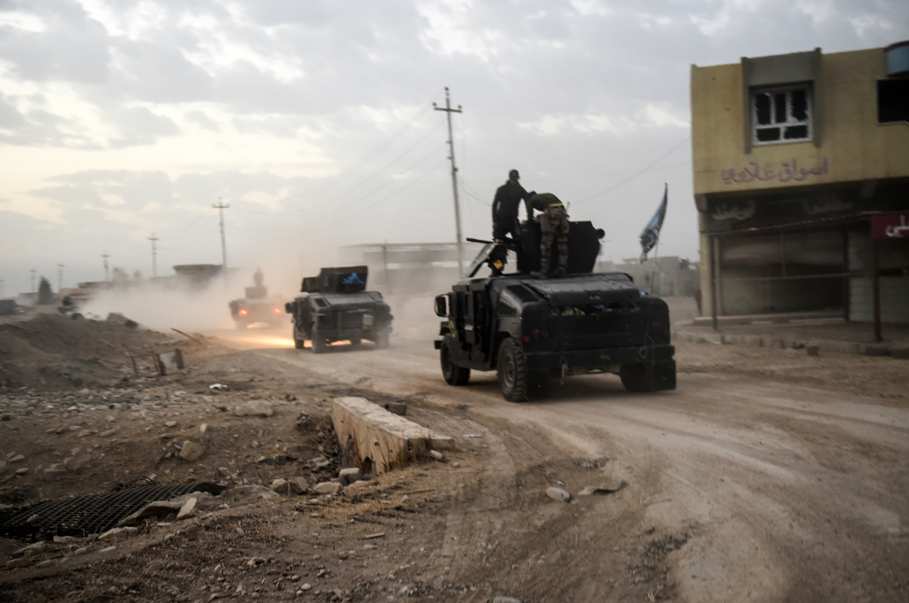 Members of the Iraqi Counter Terrorism Service (CTS) drive near the village of Bazwaya, on the eastern edges of Mosul, tightening the noose on Mosul as the offensive to retake the Islamic State group stronghold entered its third week on October 31, 2016. An Iraqi colonel said CTS had recaptured Bazwaya, one of two IS-held villages that had been standing between Iraqi forces and the eastern edges of Mosul. / AFP PHOTO / BULENT KILIC