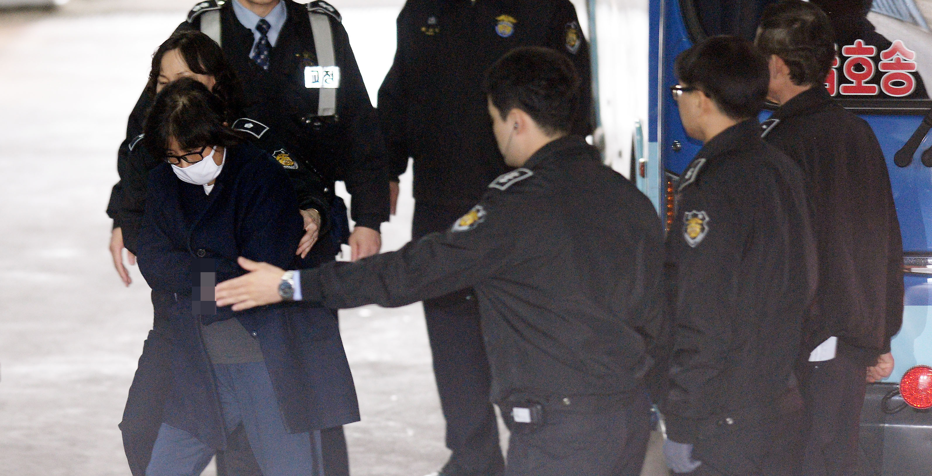 Choi Soon-Sil (L) is escorted into the Seoul Central District Prosecutor's Office in Seoul on November 3, 2016. South Korea's President Park Geun-Hye is scrambling to deflect rising public anger over suggestions that Choi -- the daughter of a shadowy religious figure -- vetted presidential speeches, had access to classified documents, and used her influence for personal enrichment. / AFP PHOTO / YONHAP / Yonhap / - South Korea OUT / REPUBLIC OF KOREA OUT NO ARCHIVES RESTRICTED TO SUBSCRIPTION USE EDITORS NOTE: IMAGES WERE PIXELATED AT SOURCE