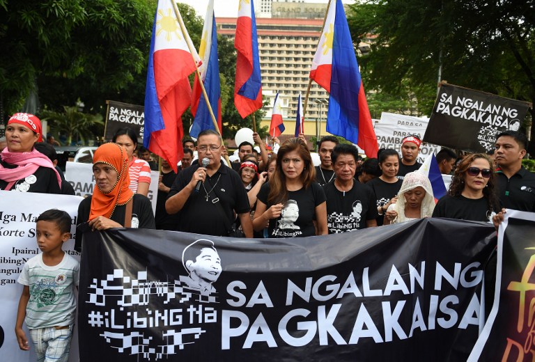 Imee Marcos (C), daughter of the late dictator Ferdinand Marcos and governor of the family's northern stronghold of Ilocos Norte, joins supporters as they march towards the Supreme Court in Manila on November 7, 2016. The court is expected to rule on November 8 whether it will approve President Rodrigo Duterte's order to allow the burial of Ferdinand Marcos at Manila's National Heroes' Cemetery 27 years after the strongman died. / AFP PHOTO / TED ALJIBE