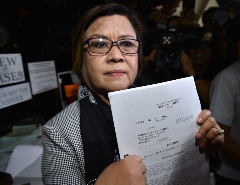 Former justice secretary and human rights chief Senator Leila de Lima shows members of the media a copy of her petition for habeas data against Philippine President Rodrigo Duterte at the Supreme Court in Manila on November 7, 2016.  De Lima, a leading critic of Duterte's bloody war on drug crime, launched a Senate probe into the surge of killings since Duterte took office on June 30, which led to her being ousted on September 19 by pro-Duterte senators as head of the Senate justice committee. / AFP PHOTO / TED ALJIBE