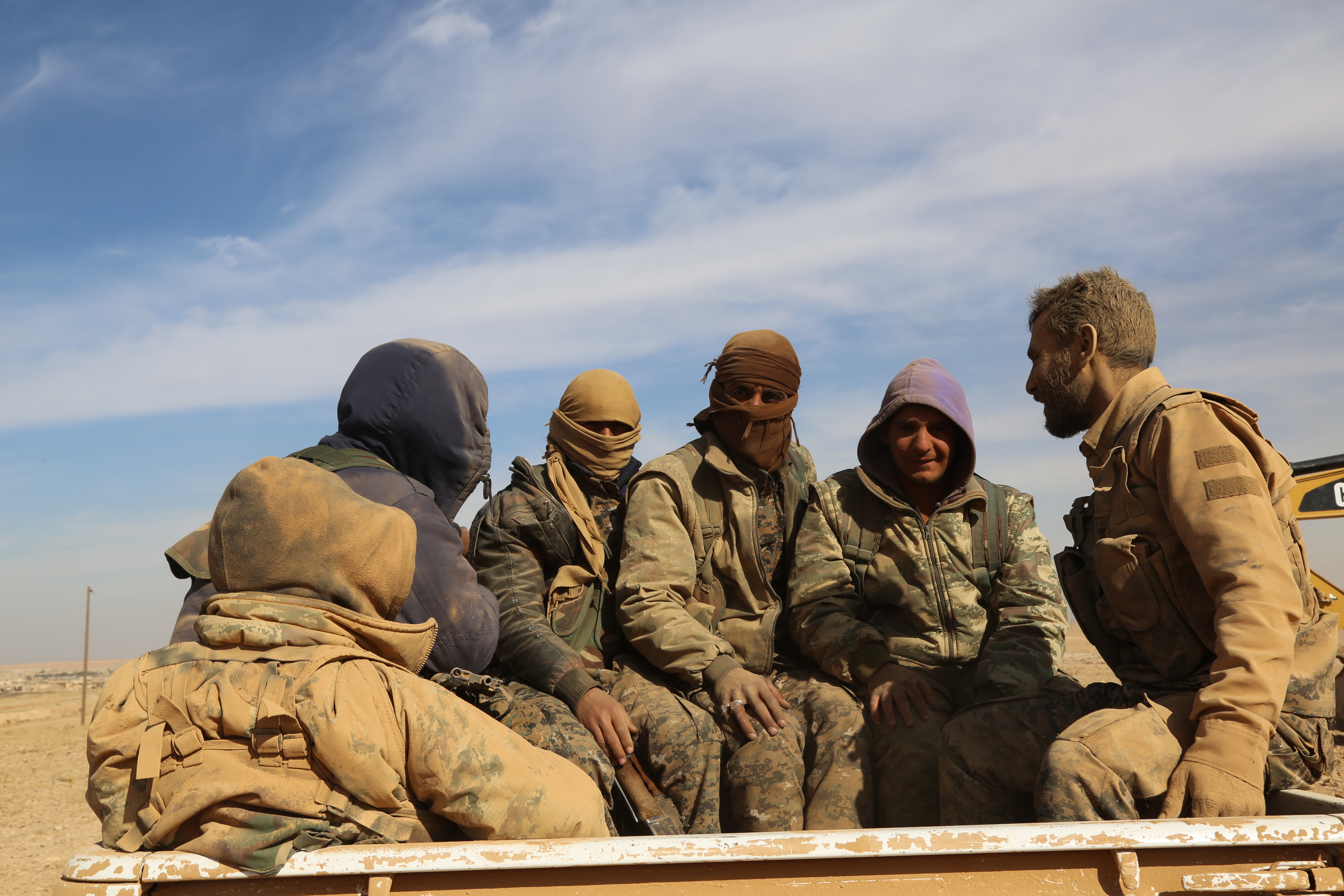 Syrian Democratic Forces (SDF), a US-backed Kurdish-Arab alliance, sit on the back of a pick-up truck in the village of Abu al-Ilaj, near the Syrian town of Ain Issa, some 50 kilometres (30 miles) north of Raqa, the Islamic State group (IS)'s de facto Syrian capital, after the SDF alliance launched an offencive to retake the IS stronghold, on November 7, 2016. / AFP PHOTO / DELIL SOULEIMAN
