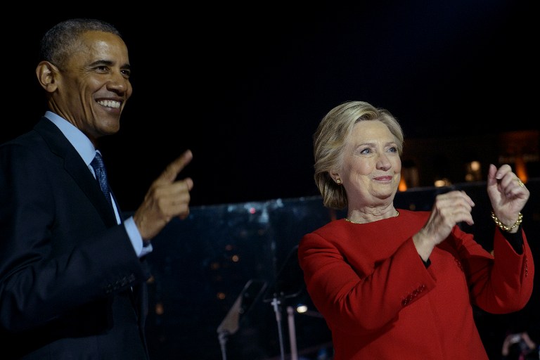 Democratic party nominee Hillary Clinton (R) walks on stage with US President Barack Obama (L) during a rally on Independence Mall, November 7, 2016 in Philadelphia, Pennsylvania. About 40,000 people flooded Independence Mall in Philadelphia for Hillary Clinton's rally with her husband Bill, President Barack Obama and his wife Michelle at her side, a campaign aide said. The attendance set a new record for Clinton, with the previous high point a rally in Ohio that drew 18,500 people, a campaign aide told reporters traveling with the candidate. / AFP PHOTO / Brendan Smialowski