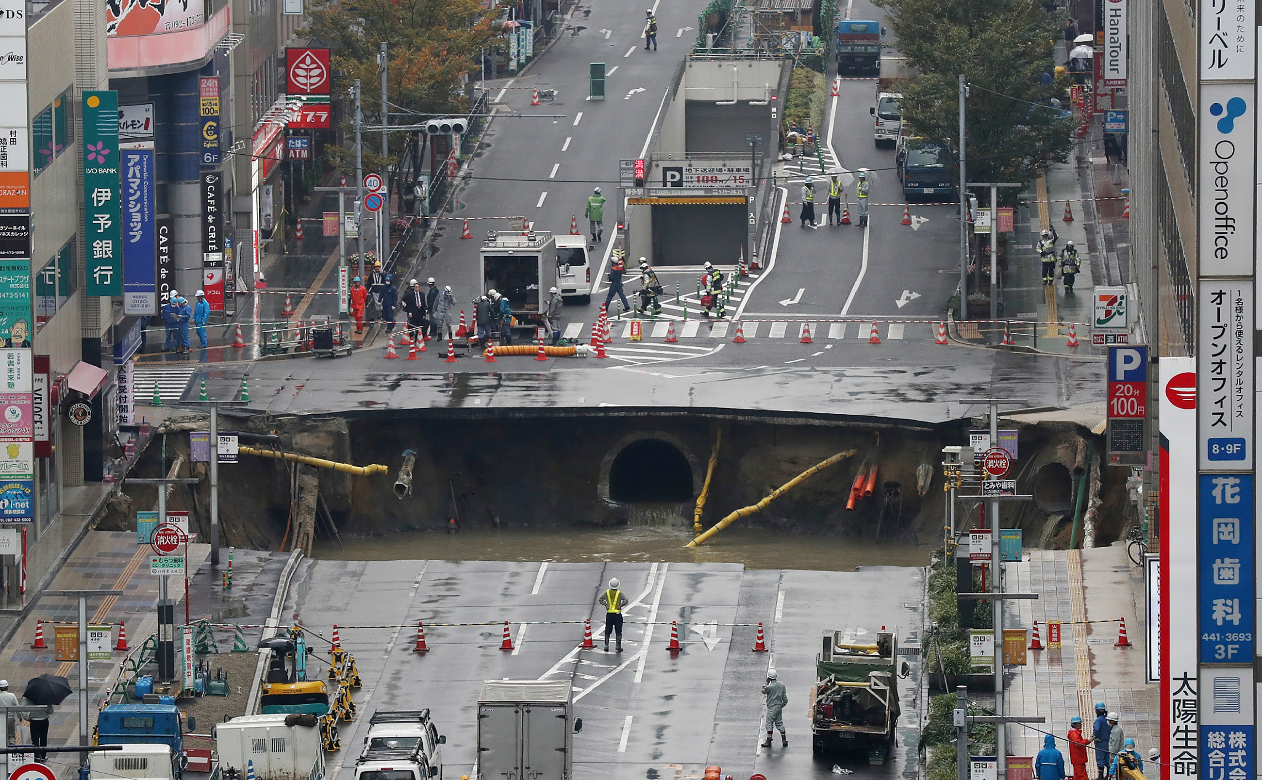 A giant sinkhole is seen in a five-lane urban boulevard, exposing support columns of nearby buildings at a traffic intersection in Fukuoka, southwestern Japan, on November 8, 2016. A giant sinkhole, measuring around 20 metres (66 feet) by 15, appeared in the middle of a busy Japanese city on November 8, swallowing part of a five-lane street near the main railway station. / AFP PHOTO / JIJI PRESS / JIJI PRESS / Japan OUT