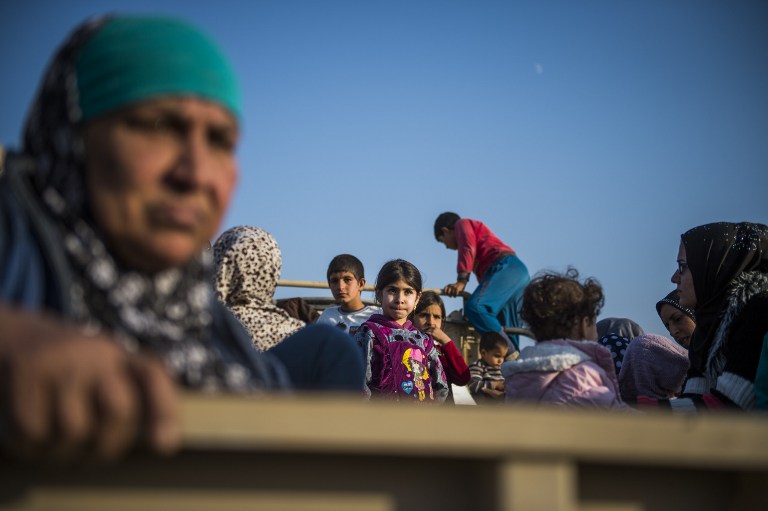Displaced Iraqis sit on trucks in the village of Shaqouli, about 35 kms east of Mosul, on November 8, 2016, as families who fled their homes in the Samah and Intissar neighbourhoods of Mosul are heading to camps in Arbil. Iraqi forces are taking part in an operation to recapture Iraq's second city Mosul from Islamic State (IS) group jihadists. / AFP PHOTO / Odd ANDERSEN