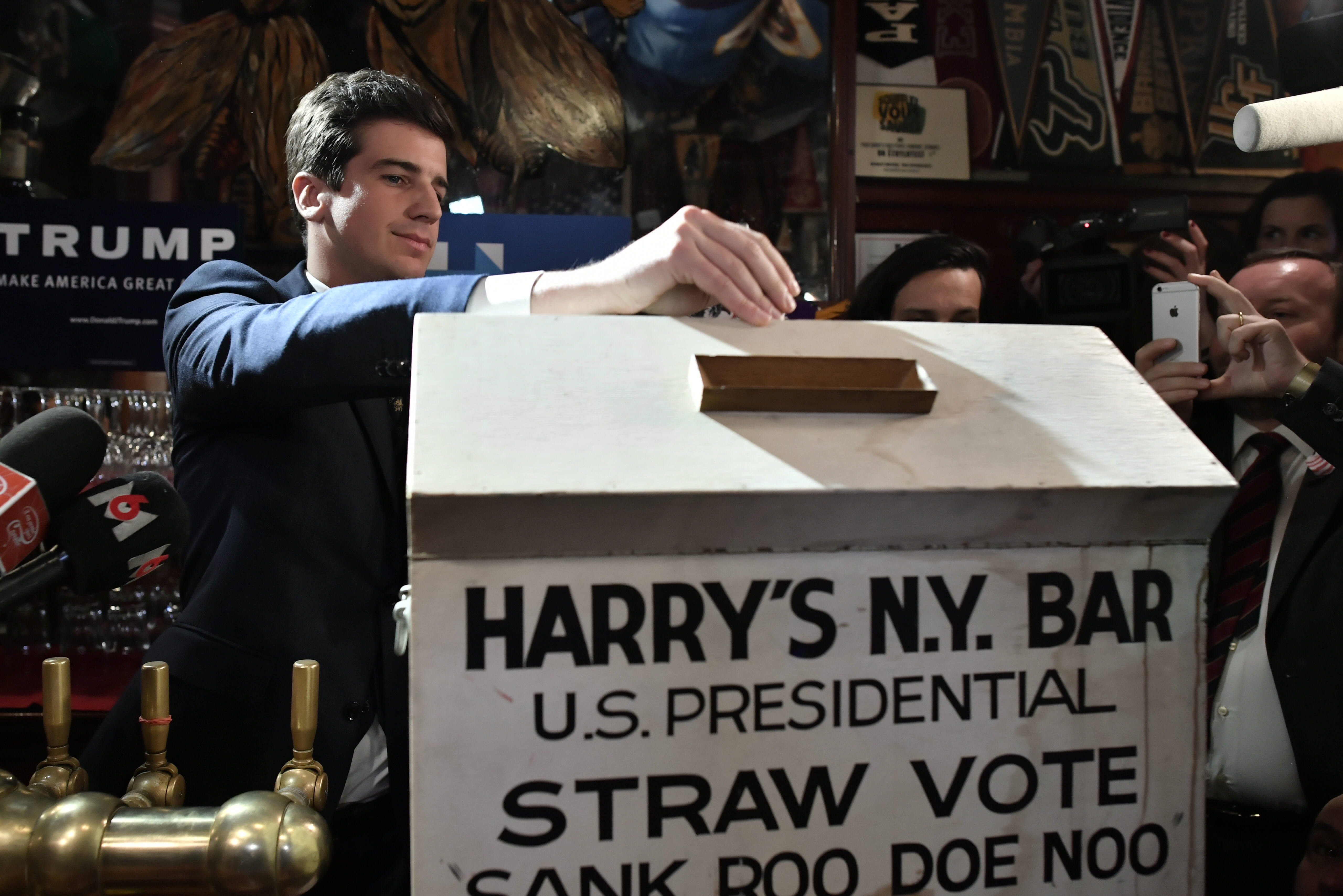 A bartender opens a ballot box at Harry's New York Bar in Paris late on November 8, 2016 during  a straw poll on election night. Expatriate Americans monitor the US election returns at Harry's New York Bar in Paris, which prides itself on having correctly predicted the outcome of US elections all but twice since launching its traditional "straw poll" in 1924. / AFP PHOTO / PHILIPPE LOPEZ