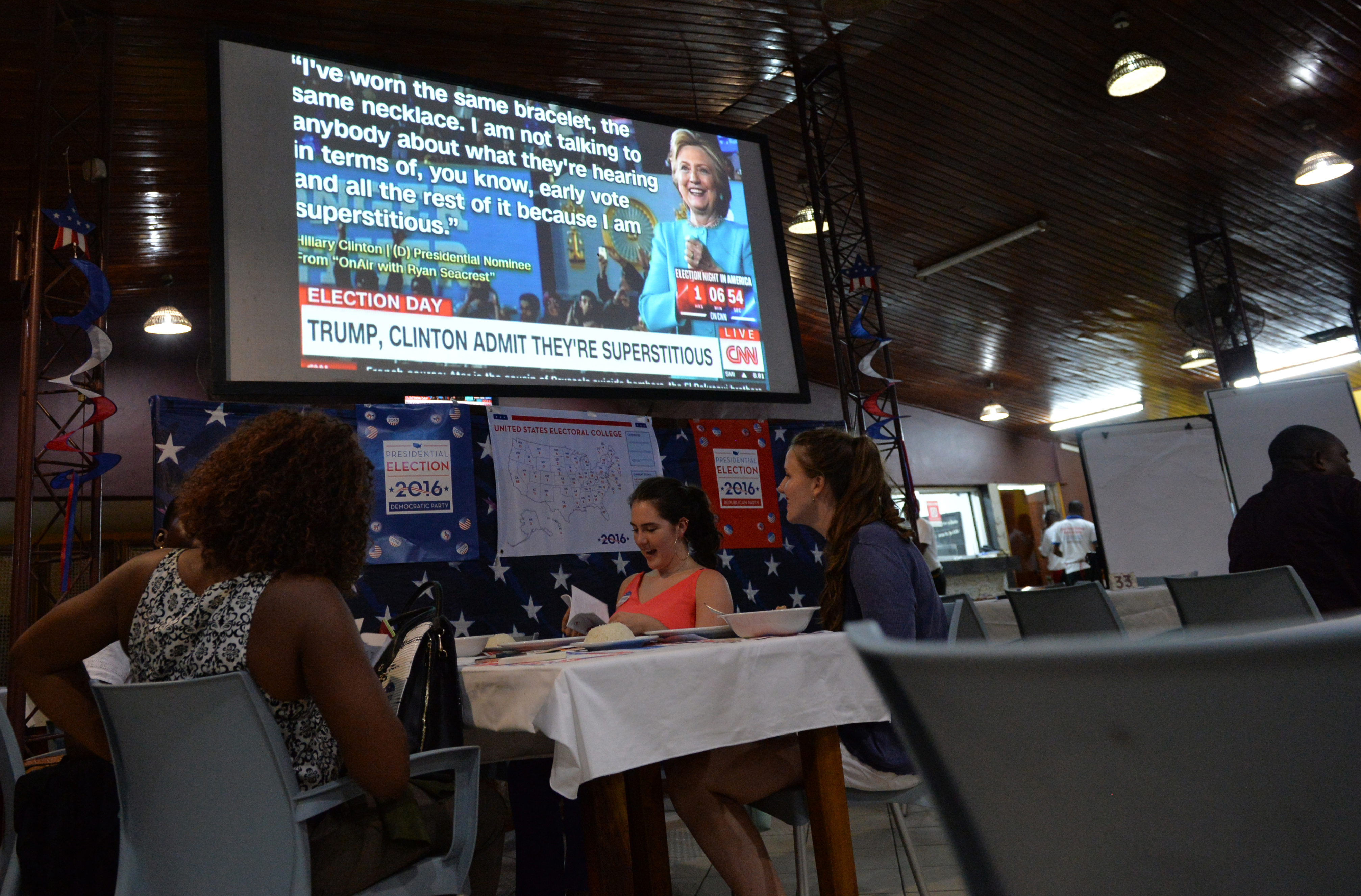 People follow he final day of the US presidential election on TV on November 8, 2016 in Abidjan. America's future hung in the balance on November 8, 2016 as millions of eager voters cast ballots to elect Democrat Hillary Clinton as their first woman president, or hand power to the billionaire populist Donald Trump. / AFP PHOTO / SIA KAMBOU