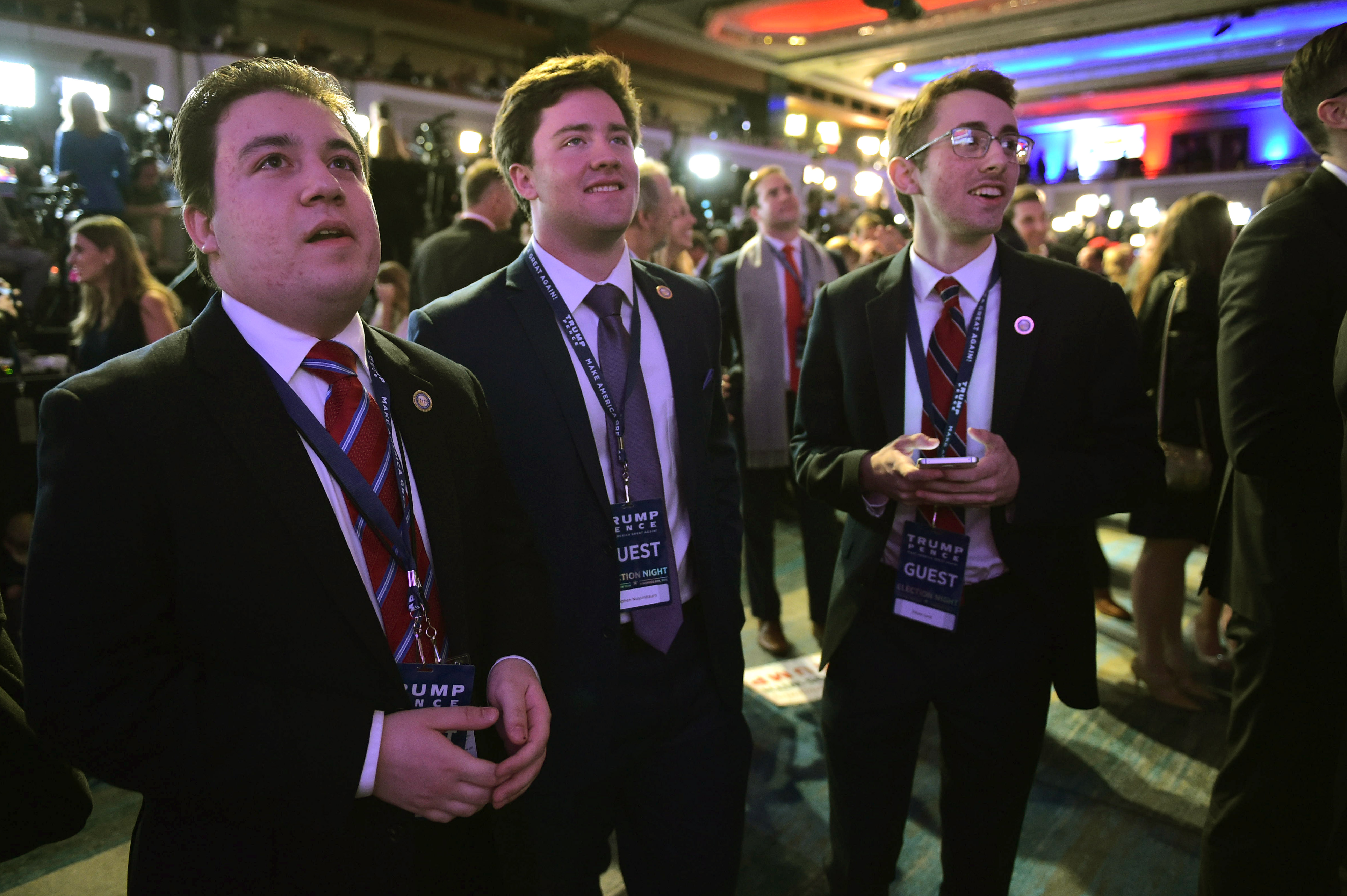 Supporters of Republican presidential nominee Donald Trump watch results unfold on a TV screen during election night at the New York Hilton Midtown in New York on November 8, 2016. / AFP PHOTO / Mandel NGAN
