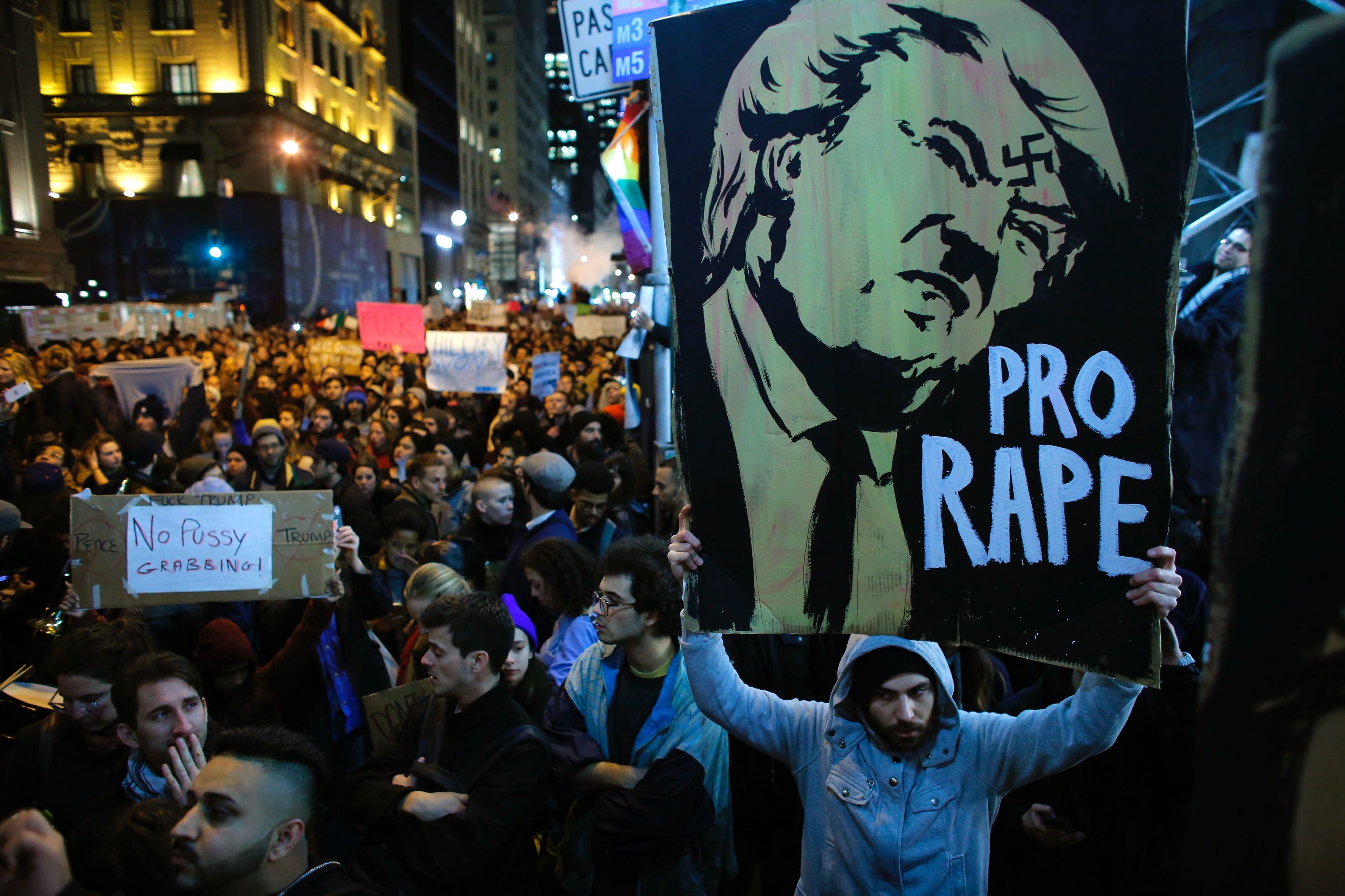 A man holds a Poster as he takes part during a protest againts elected president Donald Trump on November 9, 2016 in New York City.