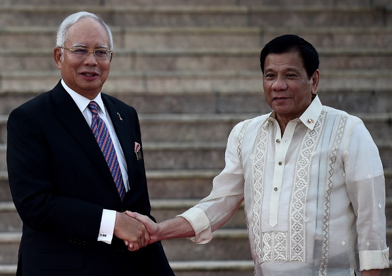 Malaysia's Prime Minister Najib Razak (L) shakes hands with Philippine President Rodrigo Duterte during a welcoming ceremony at the prime minister's office in Putrajaya on November 10, 2016. / AFP PHOTO / MANAN VATSYAYANA
