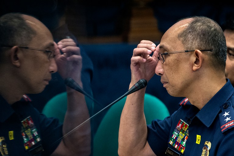 A reflection of Philippine National Police (PNP) deputy chief for operations Benjamin Magalong is seen on a pillar as he answers questions during the senate hearing into the death of Albuera Mayor Rolando Espinosa in Manila on November 10, 2016. Espinosa, who President Rodrigo Duterte named as being involved in the illegal drug trade, was shot dead in jail on November 5, police said, the second local official implicated in narcotics to be killed in two weeks. / AFP PHOTO / NOEL CELIS / The erroneous mention[s] appearing in the metadata of this photo by NOEL CELIS has been modified in AFP systems in the following manner: [adds information in caption regarding reflection in image]. Please immediately remove the erroneous mention[s] from all your online services and delete it (them) from your servers. If you have been authorized by AFP to distribute it (them) to third parties, please ensure that the same actions are carried out by them. Failure to promptly comply with these instructions will entail liability on your part for any continued or post notification usage. Therefore we thank you very much for all your attention and prompt action. We are sorry for the inconvenience this notification may cause and remain at your disposal for any further information you may require.