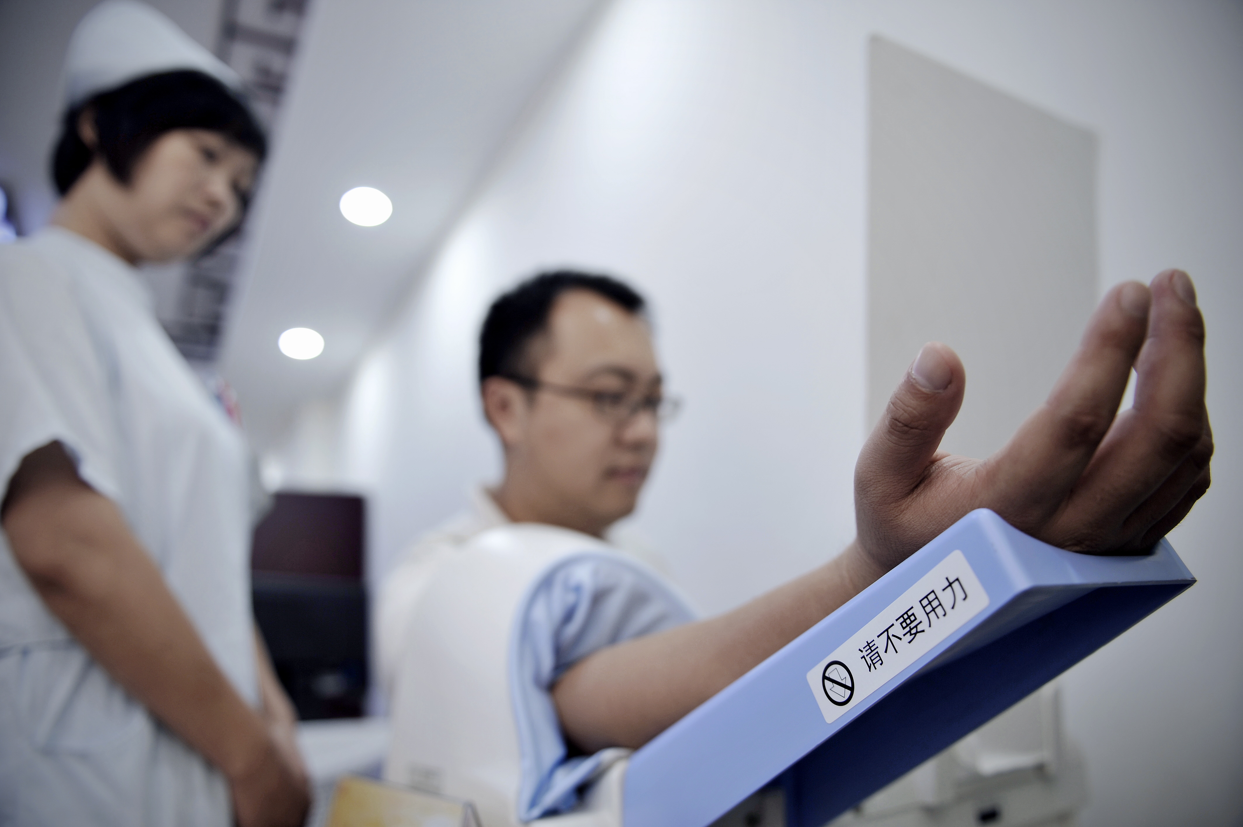 In this picture taken on September 24, 2009, a Chinese nurse (L) checks blood pressure at a community health center in Shanghai.  Hypertension plays a part in 2.3 million cardiovascular deaths in China each year, doctors reported on October 6, 2009, pointing a finger at high levels of salt in the Chinese diet.  AFP PHOTO / PHILIPPE LOPEZ / AFP PHOTO / PHILIPPE LOPEZ