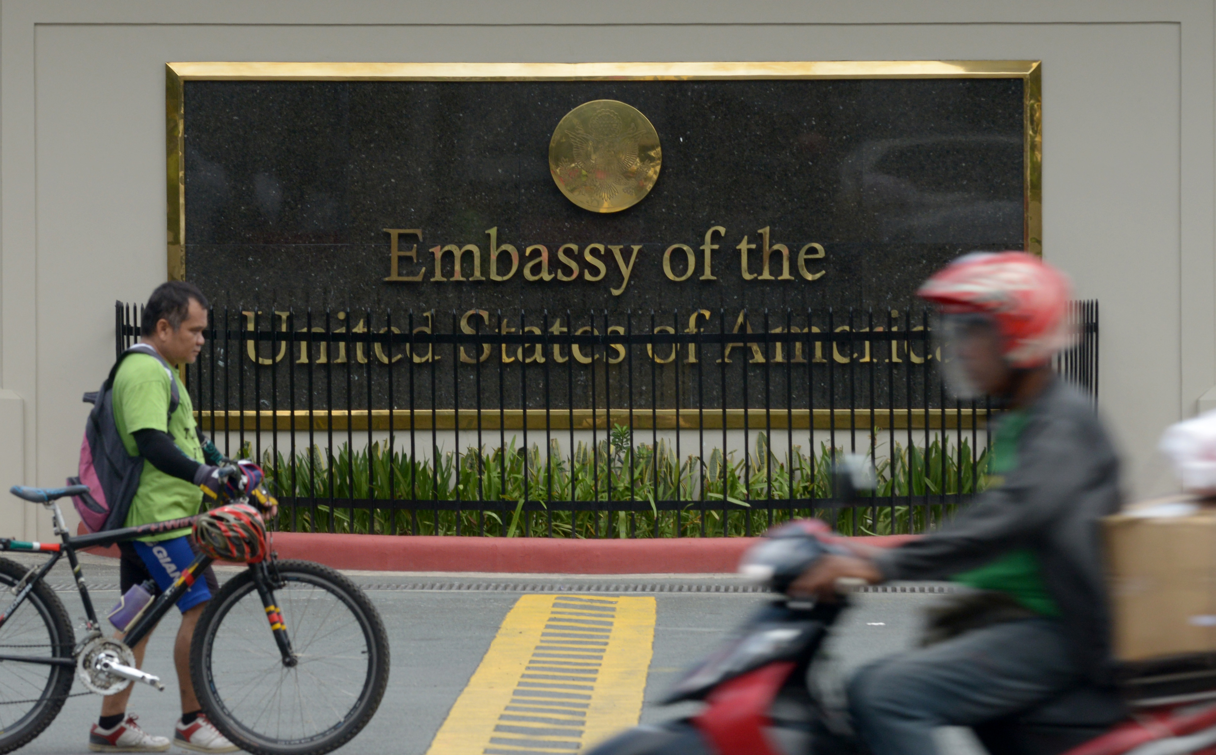 Commuters pass in front of the highly-secured US embassy in Manila on July 6, 2013. The United States issued a warning against travel to the southern Philippines, the embassy said, just days after Australia and Canada issued a similar advisory to their citizens, citing threats from criminal gangs and terrorist groups in the south, but not specifying any threat.   AFP PHOTO / Jay DIRECTO / AFP PHOTO / JAY DIRECTO