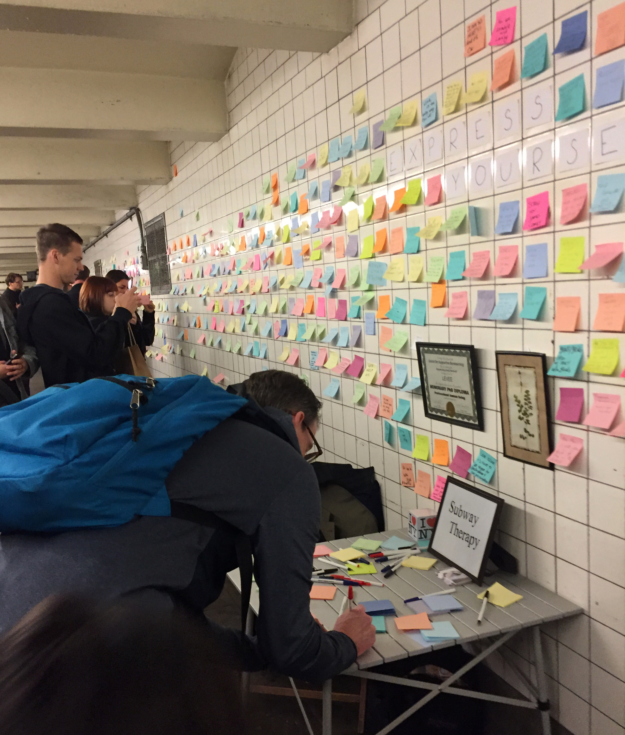 Subway riders leave post-it notes on the walls of a subway tunnel on November 10, 2016 in New York City. New York commuters are venting anger and frustration over Republican Donald Trump's shock victory by indulging in collective therapy -- writing messages on post-it notes and sticking them on a subway wall. / AFP PHOTO / Catherine Triomphe