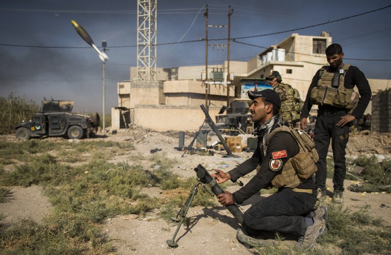 Soldiers from the Iraqi Special Forces 2nd division fire a mortar towards a position of the Islamic State (IS) group on November 11, 2016 in the eastern Mosul neighbourhood of Samah. Elite Iraqi troops battled the Islamic State group in the streets of Mosul, as the UN reported IS jihadists had executed dozens of people inside the city for alleged "treason". / AFP PHOTO / Odd ANDERSEN