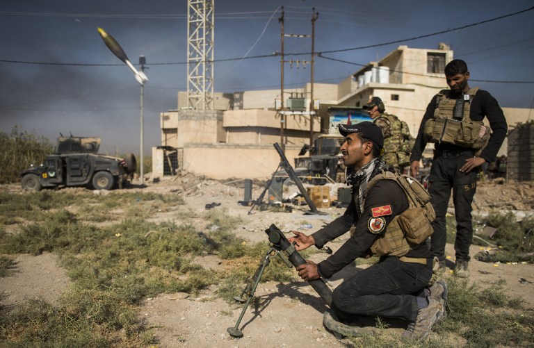 Soldiers from the Iraqi Special Forces 2nd division fire a mortar towards a position of the Islamic State (IS) group on November 11, 2016 in the eastern Mosul  neighbourhood of Samah. Elite Iraqi troops battled the Islamic State group in the streets of Mosul, as the UN reported IS jihadists had executed dozens of people inside the city for alleged "treason".  / AFP PHOTO / Odd ANDERSEN