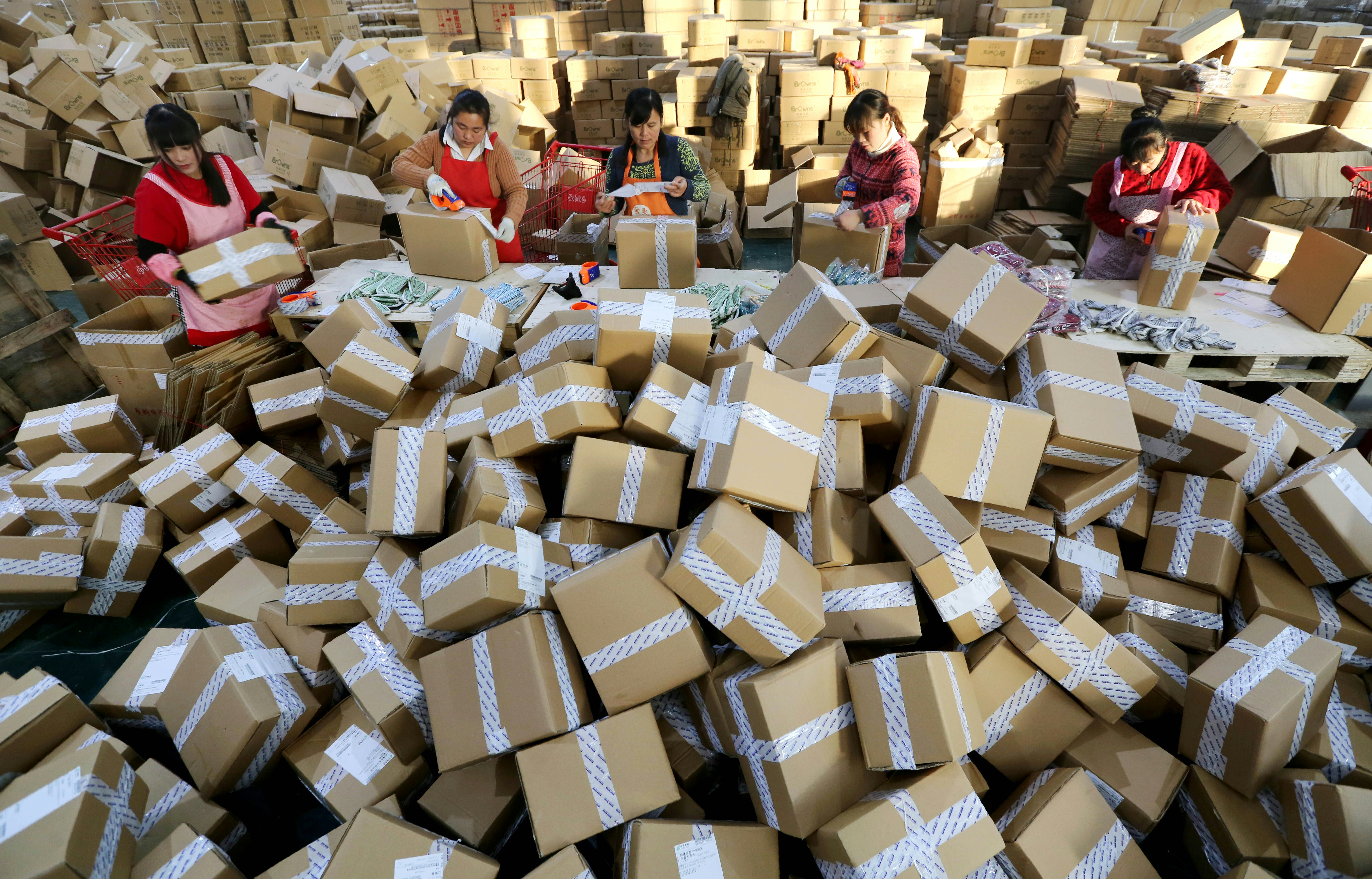 Workers prepare packages for delivery at a sorting center in Lianyungang, Jiangsu province during the Singles Day online shopping festival on November 11, 2016. Chinese shoppers unleashed a record deluge of cash online for Singles Day on November 11, Alibaba said, spending RMB 120.7 billion (USD17.8 billion) with the e-commerce giant in the world's biggest online shopping promotion. / AFP PHOTO / STR / China OUT