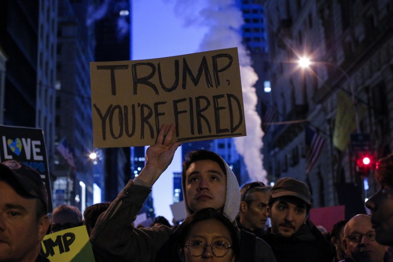 Demonstrators protest against US President-elect Donald Trump in front of Trump Tower on November 12, 2016 in New York. Americans spilled into the streets Saturday for a new day of protests against Donald Trump, even as the president-elect appeared to back away from the fiery rhetoric that propelled him to the White House. / AFP PHOTO / KENA BETANCUR