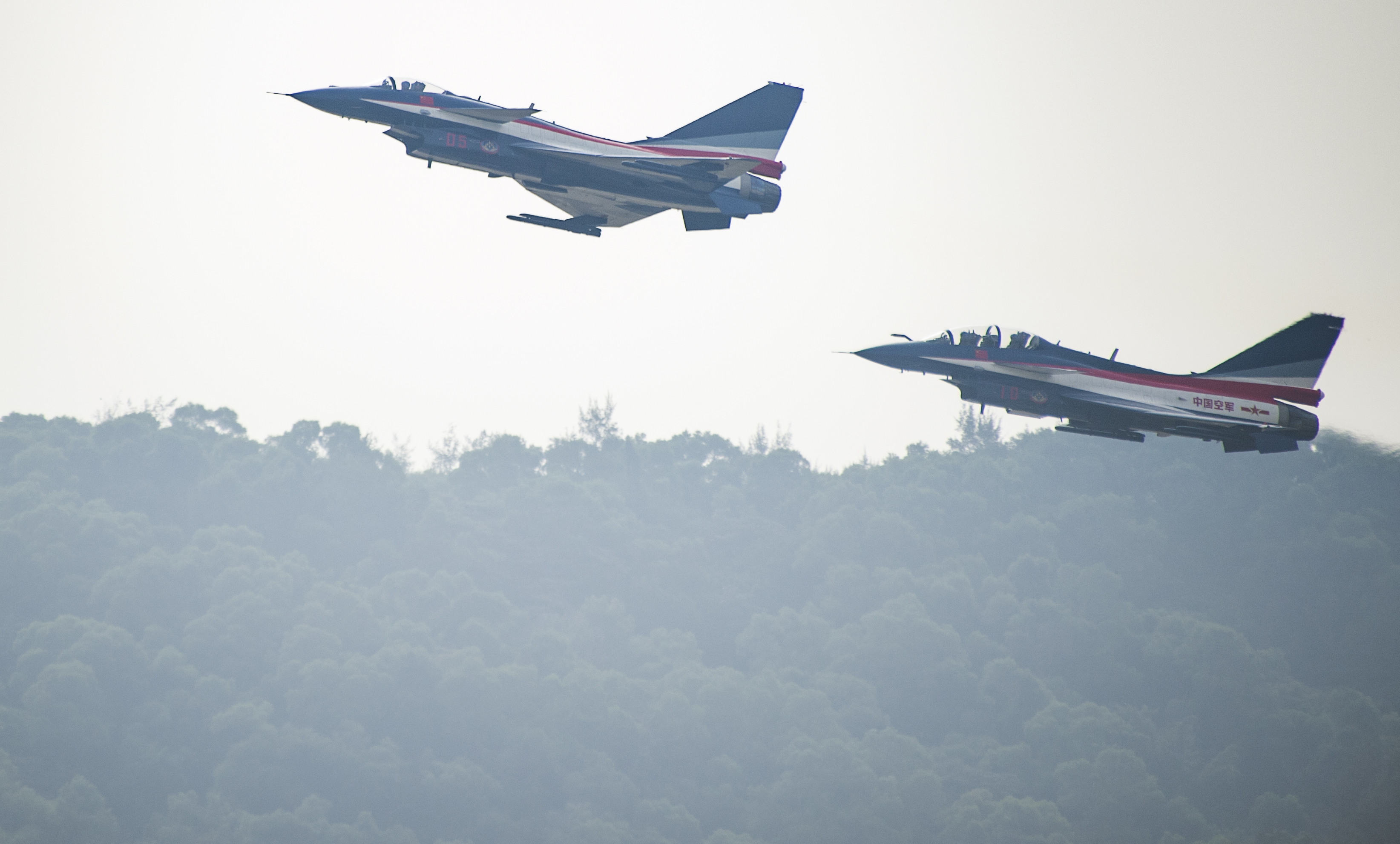 This picture taken on November 11, 2014 shows Chinese female J-10 fighter pilot Yu Xu (R plane back seat ) performing at the Airshow China in Zhuhai, south China's Guangdong province. The first woman to fly China's J-10 fighter plane was killed in a crash during an aerobatics training exercise, state-run media reported on November 14, 2016. Yu Xu, 30, a member of the Chinese air force's "August 1st" aerobatic display team, ejected from her aircraft during a training exercise in the northern province of Hebei at the weekend, the China Daily newspaper said. / AFP PHOTO / JOHANNES EISELE