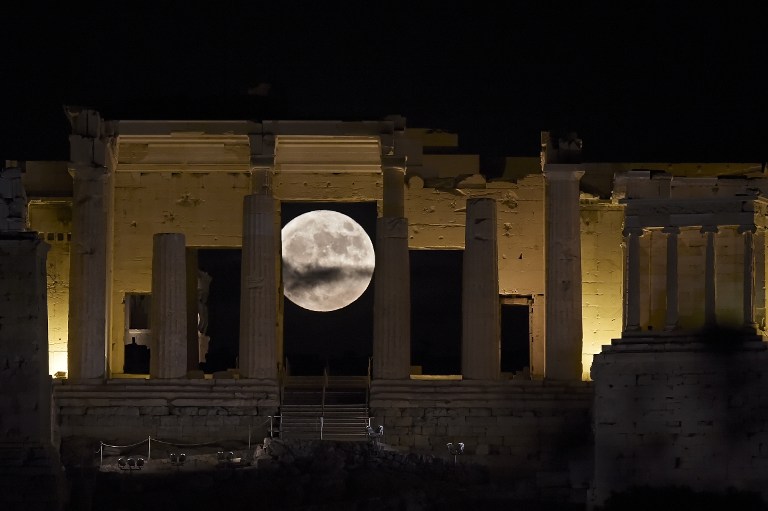 The 'Supermoon' rises behind the Propylaea above the Ancient Acropolis hill in Athens on November 14, 2016.  The moon will be the closest to Earth since 1948 at a distance of 356,509 kilometres (221,524 miles), creating what NASA described as "an extra-supermoon". / AFP PHOTO / ARIS MESSINIS