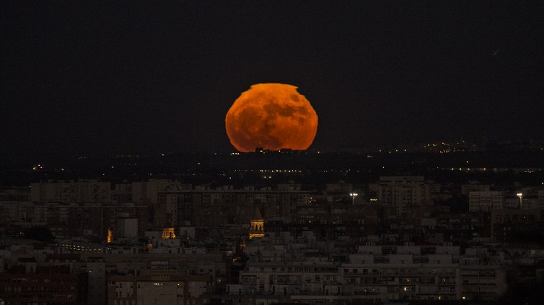 A supermoon rises over Sevilla on November 14, 2016. The phenomenon happens when the moon is full at the same time as, or very near, perigee -- its closest point to Earth on an elliptical, monthly orbit. It was the closest to Earth since 1948 at a distance of 356,509 kilometres (221,524 miles), creating what NASA described as "an extra-supermoon".  / AFP PHOTO / CRISTINA QUICLER
