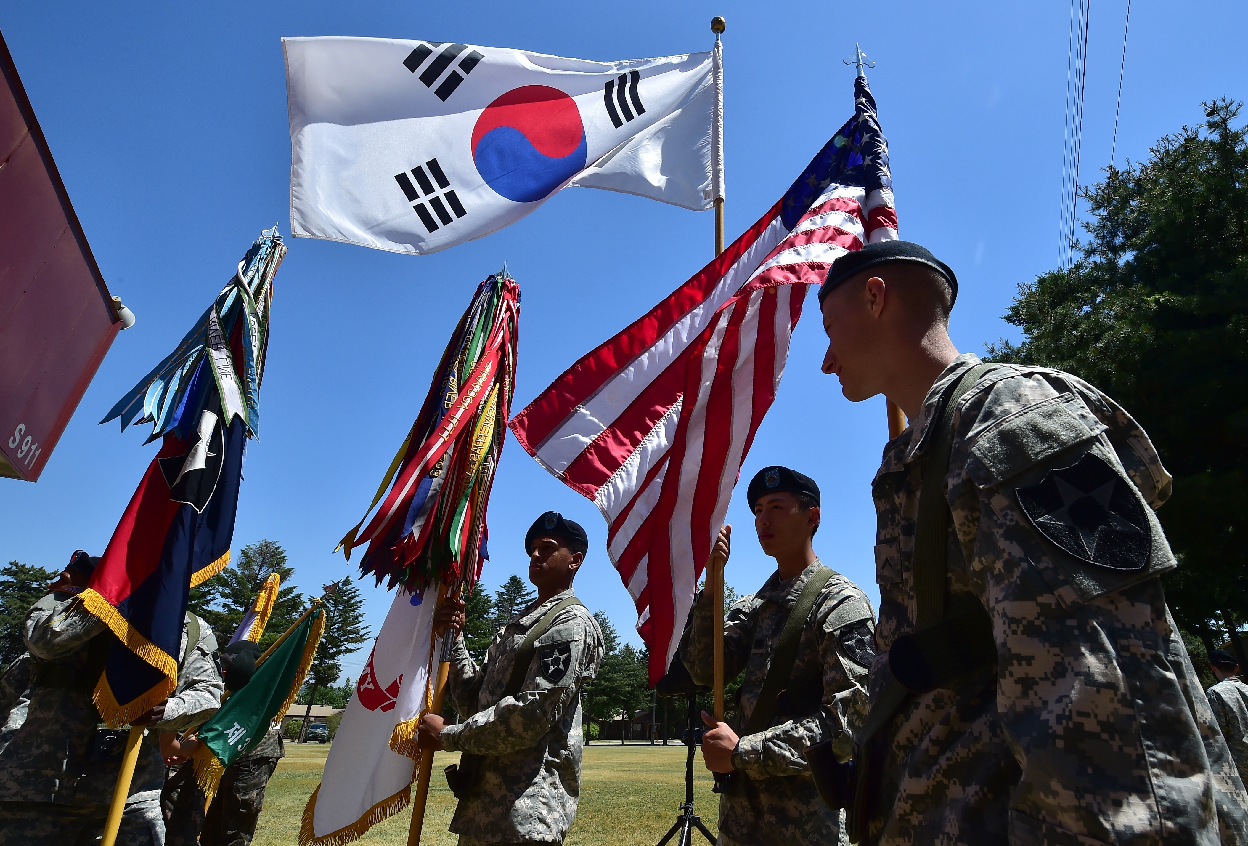 (FILES) This file photo taken on June 3, 2015 shows US soldiers holding the flags of South Korea (top) and the US (R) before a South Korea-US Combined Division activation ceremony at a US Army base in Uijeongbu, just north of Seoul. Donald Trump's shock comments about the possible benefits if Japan and South Korea develop atomic weapons undermine the US nuclear deterrent, with any new arsenal likely to have "dire consequences" for East Asia, defence experts say. / AFP PHOTO / JUNG YEON-JE / TO GO WITH AFP STORY JAPAN-SKOREA-US-DIPLOMACY-NUCLEAR-DEFENCE,ANALYSIS BY URSULA HYZY