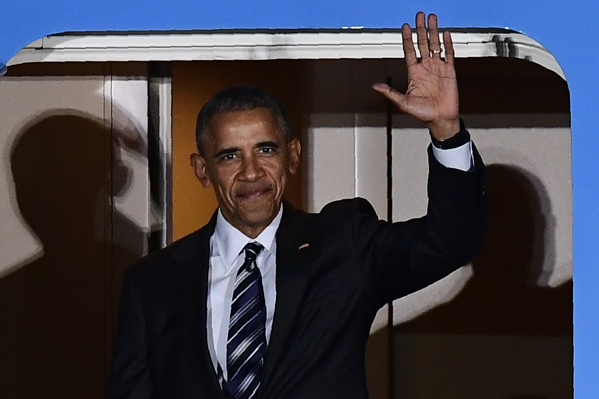 US President Barack Obama waves as he disembarks from Air Force One on November 16, 2016 at Berlin's Tegel airport. US President Barack Obama pays a farewell visit to German Chancellor Angela Merkel, widely seen as the new standard bearer of liberal democracy since the election of Donald Trump. / AFP PHOTO / TOBIAS SCHWARZ
