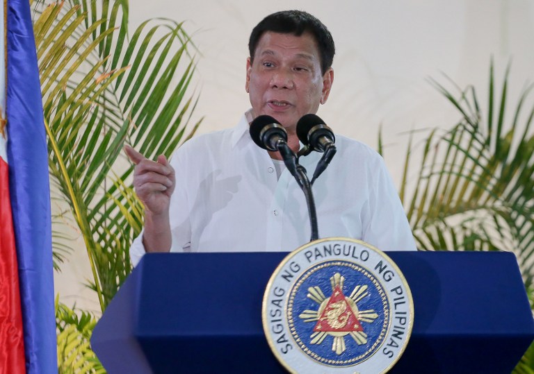 Philippine President Rodrigo Duterte gestures as he delivers a speech, prior to his departure for the APEC summit in Peru, at Davo airport, in southern island of Mindanao on November 17, 2016. Duterte threatened on November 17 to do a Russia and pull his country out of the International Criminal Court, incensed at foreign criticism of alleged extrajudicial killings in his deadly drug war. Russia on November 16 formally withdrew its signature to the ICC's founding Rome Statute, calling the tribunal's work "one-sided and inefficient". / AFP PHOTO / MANMAN DEJETO