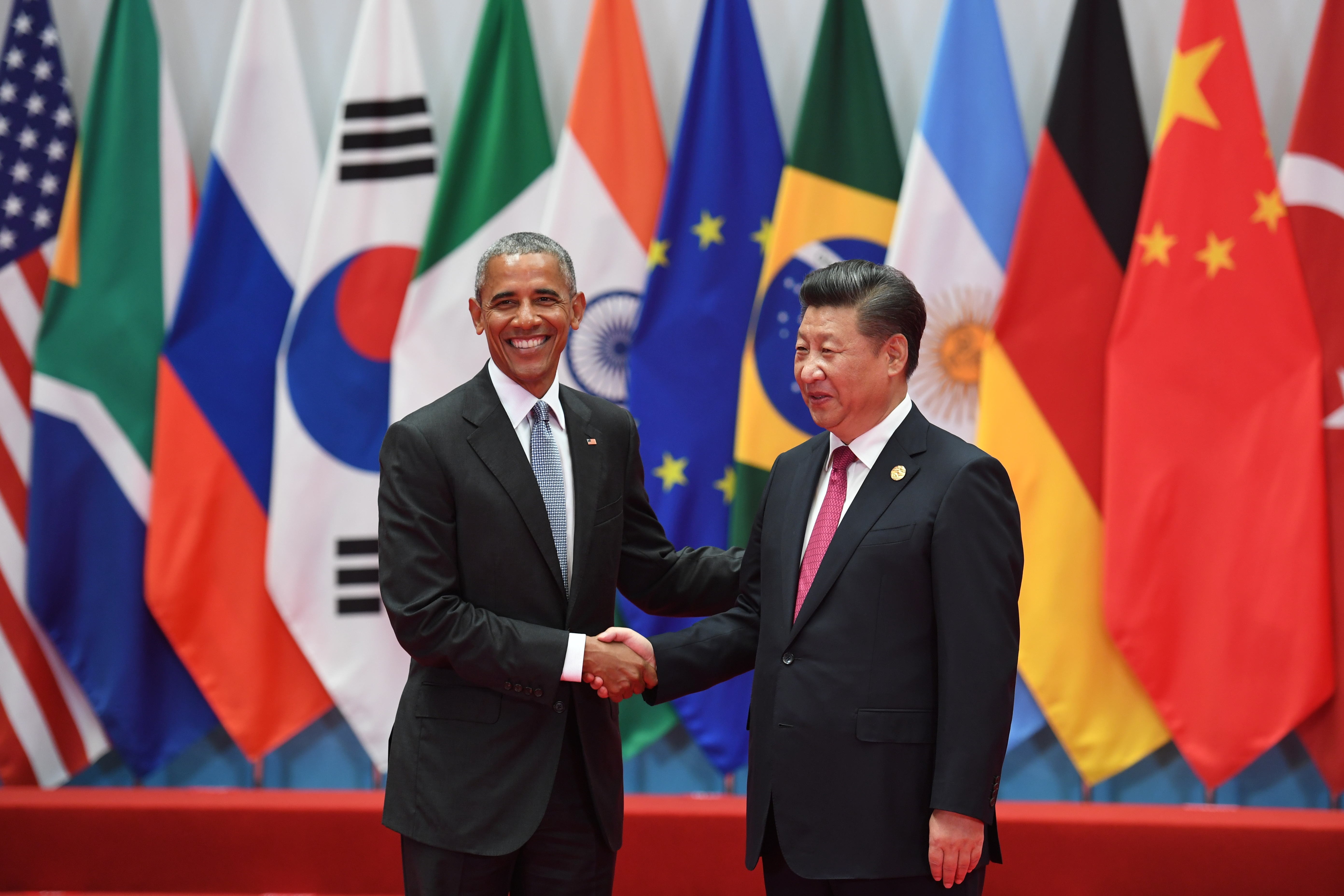 (FILES) This file photo taken on September 04, 2016 shows China's President Xi Jinping (R) shaking hands with US President Barack Obama before the G20 leaders' family photo in Hangzhou on September 4, 2016. Top world leaders meet from Thursday to try to save their cherished free trade accords from feared extinction under US President-elect Donald Trump. Outgoing US President Barack Obama sought to "rebalance" trade towards deals with Asia and the Pacific. But Trump has rejected Obama's signature trade initiative in the Asia-Pacific region, the Trans-Pacific Partnership (TPP), as a "terrible deal." / AFP PHOTO / Greg BAKER