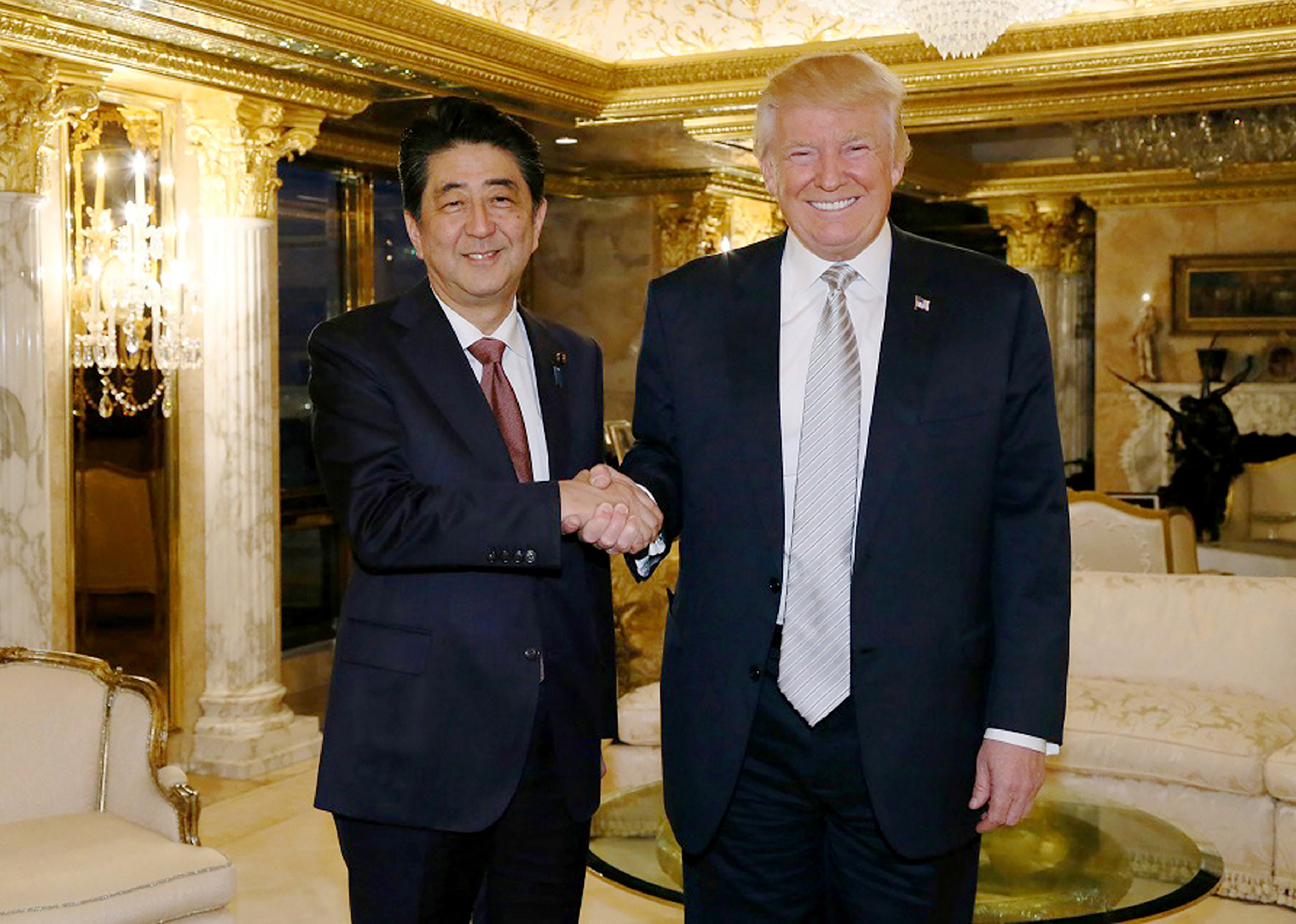 This handout picture from Japan's Cabinet Secretariat released on November 18, 2016 shows Japan's Prime Minister Shinzo Abe (L) shaking hands with US President-elect Donald Trump in New York. Abe voiced confidence on November 17 about Trump as he became the first foreign leader to meet the US president-elect, who was narrowing in on cabinet choices. / AFP PHOTO / Cabinet Secretariat / STR / HANDOUT RESTRICTED TO EDITORIAL USE - MANDATORY CREDIT "AFP PHOTO / CABINET SECRETARIAT" - NO MARKETING - NO ADVERTISING CAMPAIGNS - DISTRIBUTED AS A SERVICE TO CLIENTS